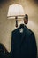 Stylish blue suit for groom hanging on lamp in hotel room. Morning preparation before wedding ceremony. Clothes for business