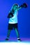Stylish boy, beginner boxer training isolated over blue background in neon light. Concept of sport, fashion, studying