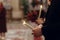 stylish bride and groom holding candles in hands at wedding ceremony in church. spiritual couple. space for text