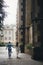 Stylish bride and groom running on background of old church in rainy street. Provence wedding. Beautiful emotional wedding couple