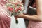 Stylish bride with rustic bouquet, bridesmaids with pink roses,