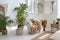 Stylish bright loft cozy living room with armchair, green plants, jalousie, white brick walls and wooden floor