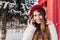 Stylish british portrait of amazing young woman with long brunette hair in red hat talking on phone on street full with