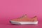 stylish brown sneakers with laces on a pink background. 3D render