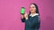 Stylish brunette Jewess with blue Afro braids is dancing with a phone in her hands on a green screen