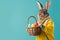 stylish bunny wearing sports suit holding eggs basket, standing against plan background, Easter eggs in a basket with a bunny