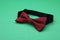 Stylish burgundy bow tie with polka dot pattern on green