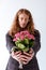 stylish businessman with curly hair showing potted pink flowers