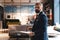 Stylish businessman standing near table in the office and reading documents