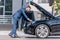 stylish businessman in suit repairing car