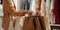 Stylish buyer holding shopping bags near clothes in showroom