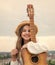 stylish child girl playing guitar outdoor, country music