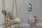 Stylish child`s room with adorable painting and hanging chair