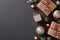 Stylish Christmas composition with elegant bronze gift boxes and baubles on black background. Luxury festive design, perfect for