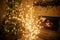 Stylish christmas illuminated tree on background of decorated tree with golden lights bokeh and burning fireplace in evening room