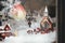 Stylish christmas little city decoration. Building, church, snow and lantern - christmas city in miniature in window. Xmas festive