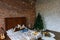 Stylish Christmas loft interior,cozy bedroom with wooden bed and a lot of lights with a decorated Christmas tree and a