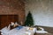 Stylish Christmas loft interior,cozy bedroom with wooden bed and a lot of lights with a decorated Christmas tree and a