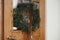 Stylish christmas rustic wreath with vintage bells and ribbon hanging on wooden doors, close up. Winter holiday preparations,