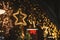 Stylish christmas star illumination and spruce branches in golden lights in evening, fairytale decoration. Atmospheric magic time