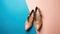 Stylish classic womens beige leather shoes with medium high heels, on blue multi-colored paper background. Copy space, flat lay.