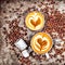 Stylish coffee in cup with froth shaped like love heart and coffee beans strewn about