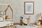 Stylish composition of cozy scandi child`s room interior with mock up poster frame, bed, rattan basket, plush and wooden toys.
