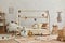 Stylish composition of cozy scandinavian child`s room interior with wooden bed and coffee table, plush. wooden toys and textile.