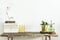 Stylish composition of creative home interior design with copy space, wooden consola, plants in hipster designed pots.
