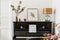 Stylish composition at living room interior with black piano, gold mock up poster frame, dried flowers, gold clock, design lamp