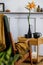 Stylish composition at living room interior with design armchair, plaid, clock, cup of coffee, flower in vase, book.