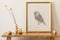 Stylish composition of living room interior with gold mock up frame, wooden bench, dried flower in vase, decoration white wall.