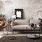 The stylish compostion at concrete living room interior with design gray sofa, wooden coffee table, desk and elegant personal