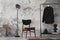 The stylish compostion at living room interior with concrete wall, chair, hanger with clothes and elegant personal accessories.