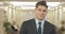 Stylish confident man in formal suit posing in business center. Portrait of handsome young Caucasian businessman