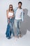 Stylish couple. Full length of beautiful young couple bonding while standing against grey background