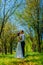 Stylish couple in love portrait, Newlywed husband and wife in circlet of flowers hugging near tree outdoors, summer nature concept
