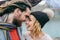 Stylish couple newlyweds smile and touching foreheads standing before a lake. Autumn wedding ceremony outdoors. Bride