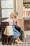 stylish couple with shopping bags and paper cups of coffee standing near piano