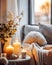 Stylish and cozy reading nook. Knitted blanket on grey sofa near side table with candles against window. Hygge, scandinavian