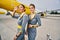 Stylish cute stewardesses standing at the airdrome