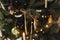 Stylish decorated christmas tree with ribbons, vintage baubles, candles and golden lights. Atmospheric winter holiday decor.