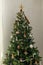 Stylish decorated christmas tree with vintage golden baubles and candles. Atmospheric winter holidays preparation. Modern