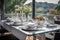 stylish dining table with white linen and silver cutlery on a scenic terrace