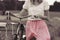 Stylish dressed girl rides on an old bicycle with a retro effect