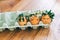 Stylish Easter eggs with cute faces in floral wreath crowns in carton tray. Modern sweet easter eggs with flowers and sleepy eyes