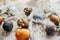 Stylish easter eggs on rustic table. Natural dyed colorful easter eggs with spring white flowers and feathers on rural textile