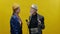 Stylish Elderly Woman On Yellow Background. She Is Wearing Hat And Glasses. Stylish Man With Beard In Hat. Man Holding