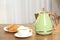 Stylish electrical kettle, cup and plate with cookies