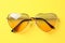 Stylish elegant heart shaped sunglasses on background, top view